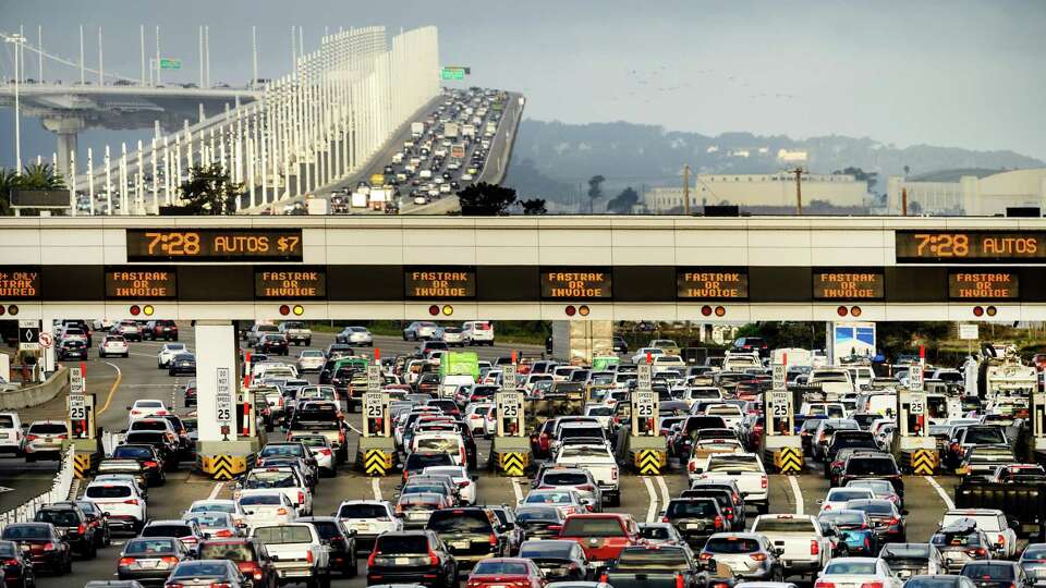 Cars and trucks approach the Bay Bridge toll plaza in Oakland, Calif.