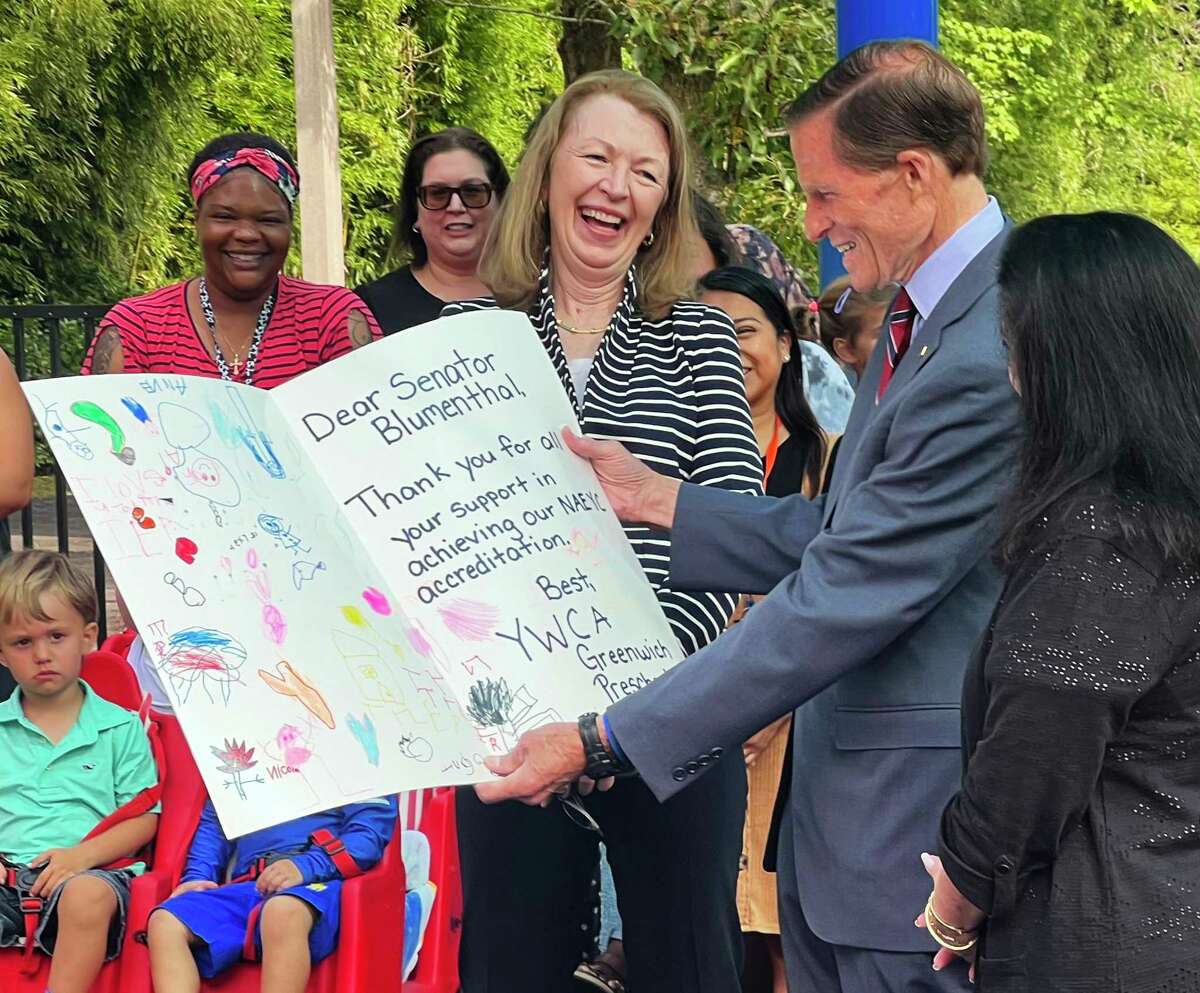 U.S. Sen. Richard Blumenthal, D-Conn., accepts a card signed by staff and students from YWCA Greenwich President and CEO Mary Lee Kiernan, left, and Director of Childhood Education Geri Smiles at the YWCA in Greenwich, Conn. Thursday, Aug. 11, 2022. Sen. Blumenthal announced a large grant for the Greenwich YWCA to expand their domestic abuse counseling services and their child care programs.