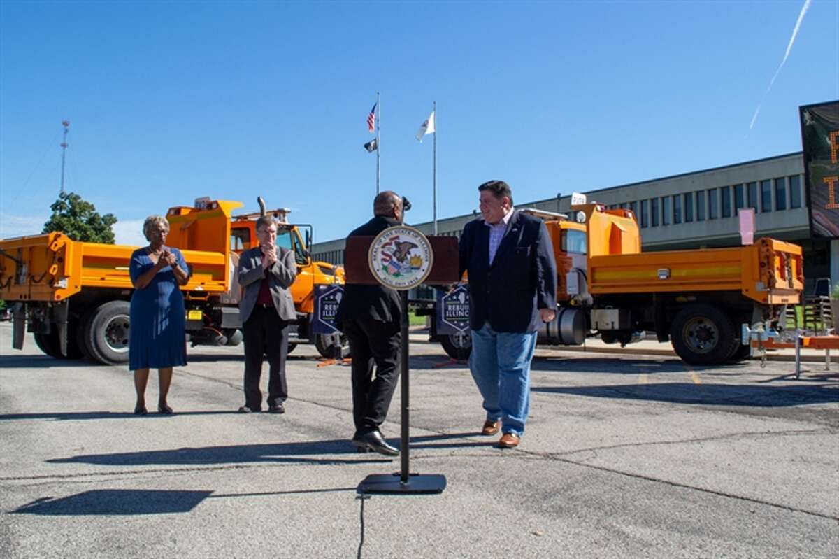 Gov. J.B. Pritzker shakes the hand of Illinois Department of Transportation Secretary Omer Osman outside the transportation department building in Springfield. The pair and other officials outlined the state's six-year infrastructure spending plan.