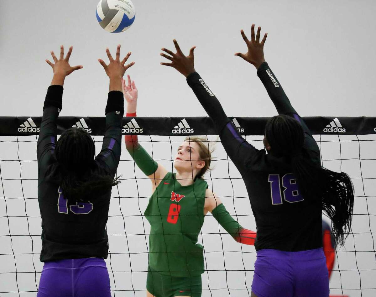 The Woodlands' Makenzie Weddel (8) tips the ball past Fulshear's Olivia Drayden (13) and Yosola Adeleke (18) in the second set of a non-district high school volleyball match during the Adidas John Turner Classic, Friday, Aug. 12, 2022, in Webster.