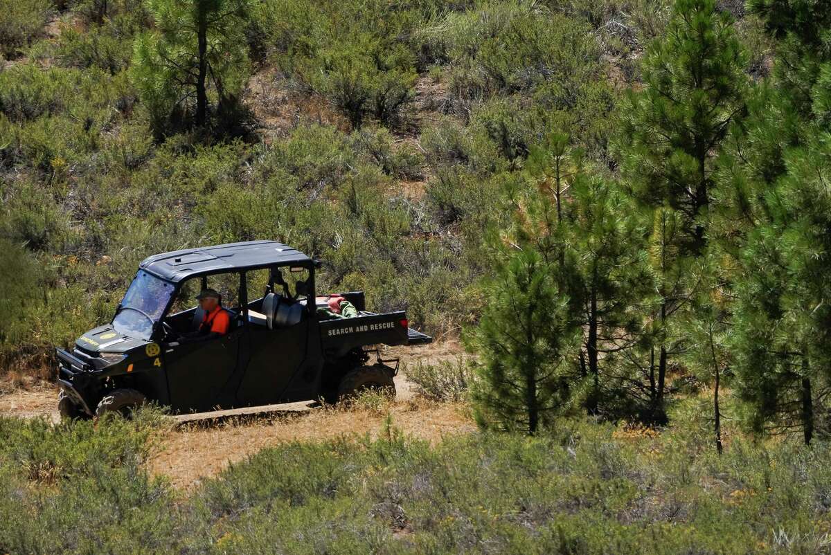 A member of search and rescue searches an area near the Prosser Lake Family campground, just north of Truckee, Calif., on Friday, Aug. 12, 2022. There is a large effort to locate Kiely Rodni, a Truckee teenager who has been missing since last weekend.