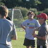 Reed City coach Courtney Murphy (wearing cap) talks to her soccer team after a Thursday practice.