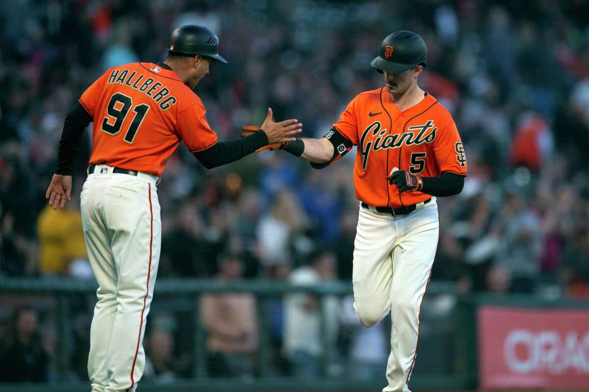 San Francisco Giants' Mike Yastrzemski (5) gets a congratulatory handshake from third base coach Mark Hallberg (91) after hitting a solo home run off Pittsburgh Pirates starting pitcher Bryse Wilson during the second inning of a baseball game Friday, Aug. 12, 2022, in San Francisco. (AP Photo/D. Ross Cameron)