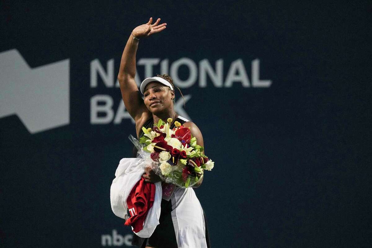 Serena Williams, of the United States, leaves the court carrying flowers and waving to fans after her loss to Belinda Bencic, of Switzerland, during the National Bank Open tennis tournament Wednesday, Aug. 10, 2022, in Toronto.