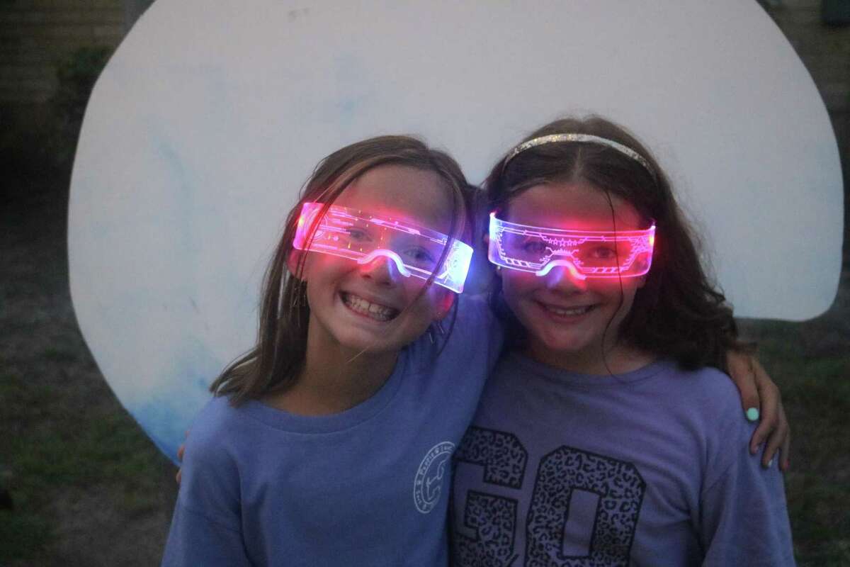 As darkness descended, Lily Ainsworth (left) and Isabella Follmar showed off their extremely colorful glasses.