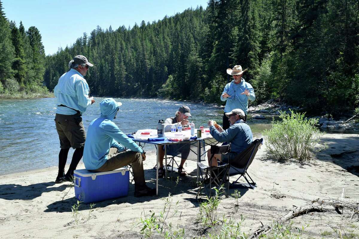 Anglers and guides enjoy pulled pork sandwiches on the banks of the scenic St. Mary River, west of Fernie.