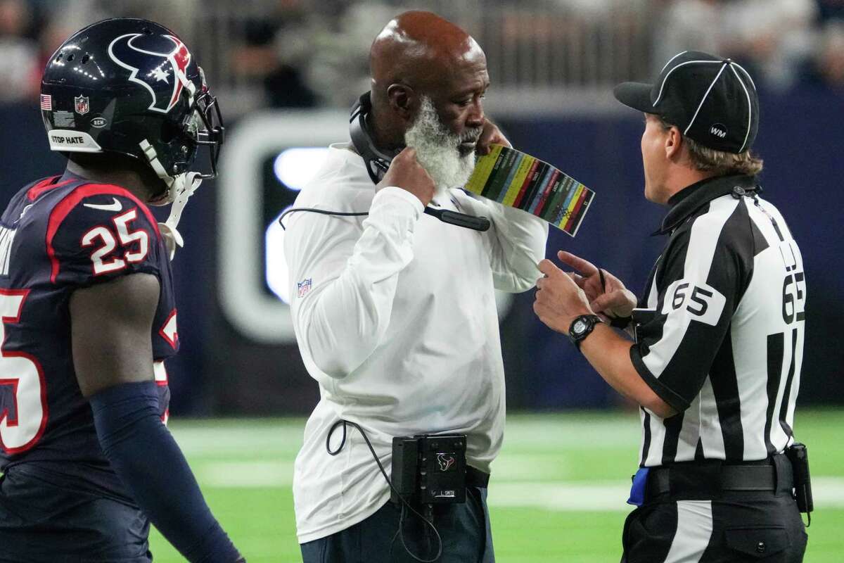 Houston Texans head coach Lovie Smith talks to line judge Walt Coleman IV (65) during the first half of an NFL football game Saturday, Aug. 13, 2022, in Houston.