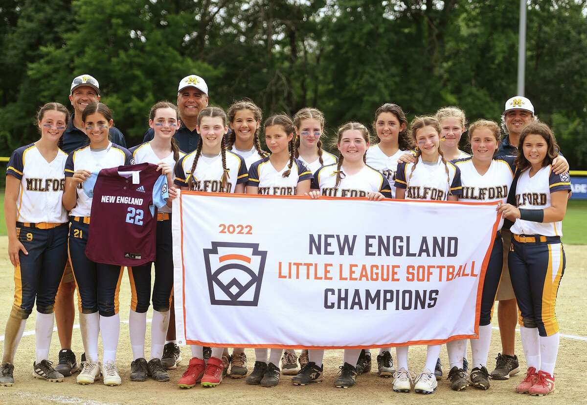 Milford players pose for a group photo with their banner following their 10-0 victory over Vermont to win the 2022 Little League Softball East Regional Tournament in Bristol, Conn. on Thursday, July 28, 2022. Milford advanced to the loser’s bracket semifinal of the Little League Softball World Series.