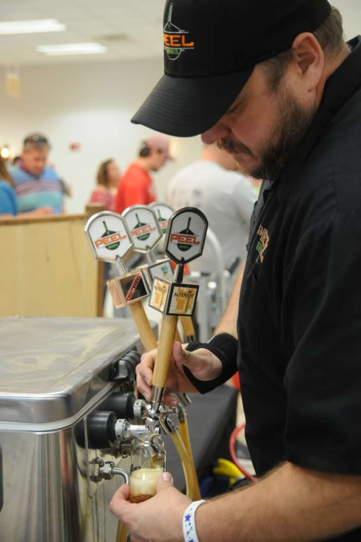 Brandon Valentine pours craft beer samples for attendees at Saturday's Hops for Heroes event in Edwardsville benefiting the Greater St. Louis Honor Flight.