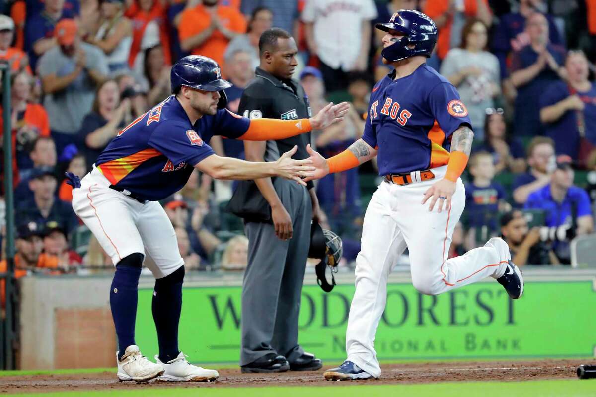 Houston Astros' Chas McCormick, left, and Christian Vazquez, right, celebrate as they both scored on an RBI-double by Jose Altuve during the second inning of a baseball game against the Oakland Athletics, Sunday, Aug. 14, 2022, in Houston.