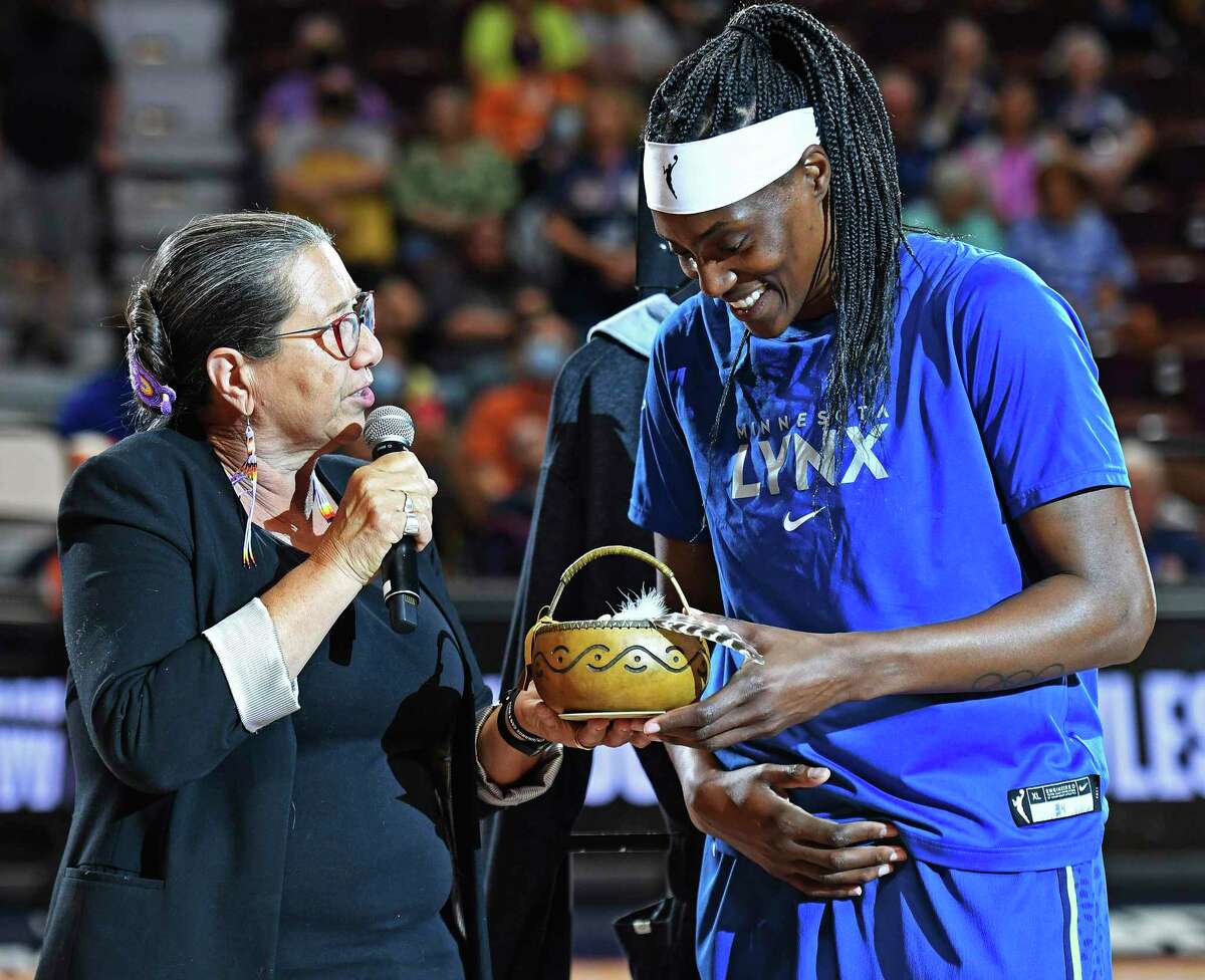 Mohegan tribal elder Beth Regan, left, presents Minnesota Lynx center Sylvia Fowles with a retirement gift before Sunday’s game against the Connecticut Sun in Uncasville. Fowles played the final game of her storied career as the Sun eliminated the Lynx from playoff contention with a 90-83 win.
