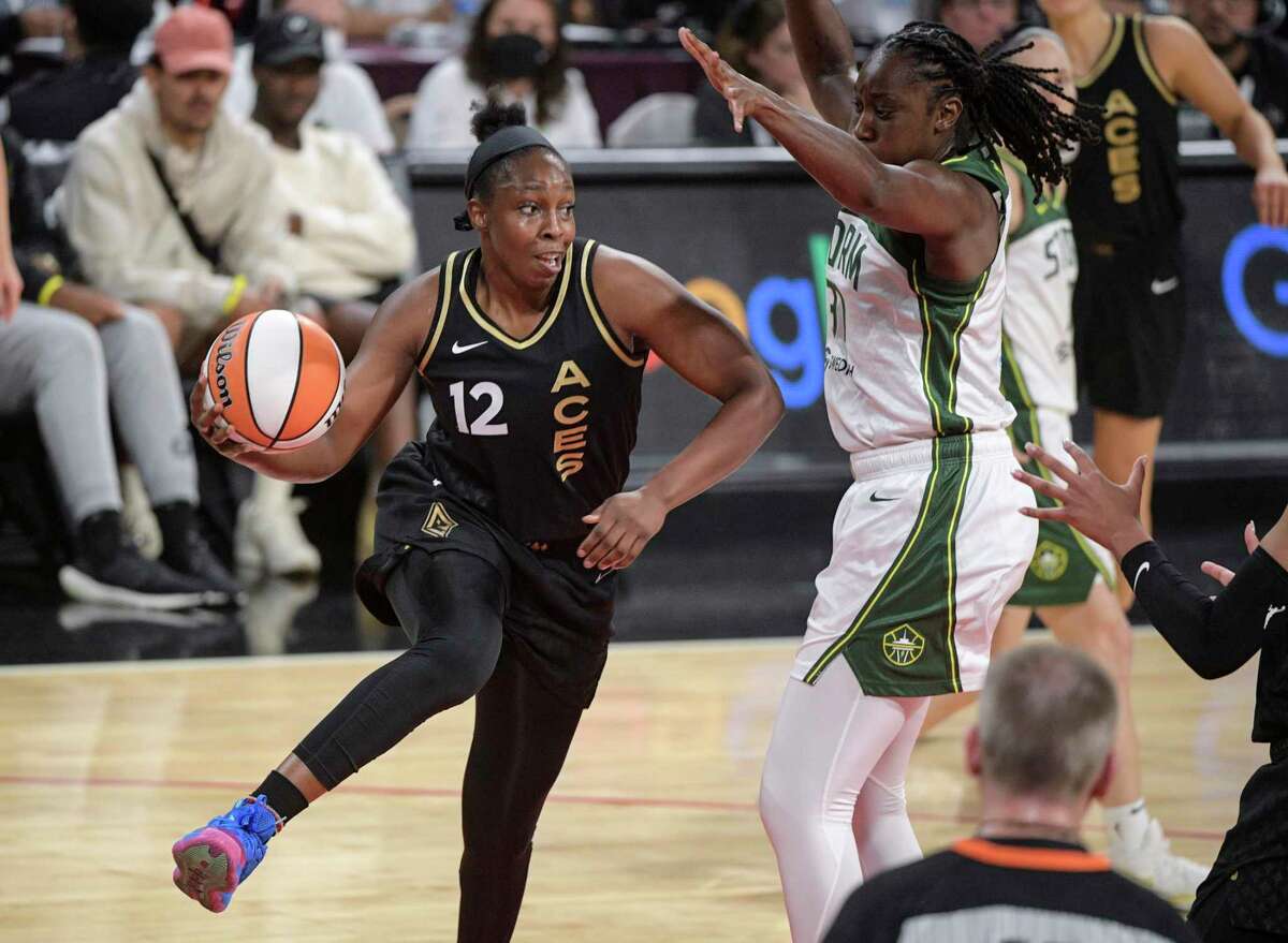 Las Vegas Aces guard Chelsea Gray (12) passes around Seattle Storm's Tina Charles during the first half of a WNBA basketball game Sunday, Aug. 14, 2022, in Las Vegas. (AP Photo/Sam Morris)