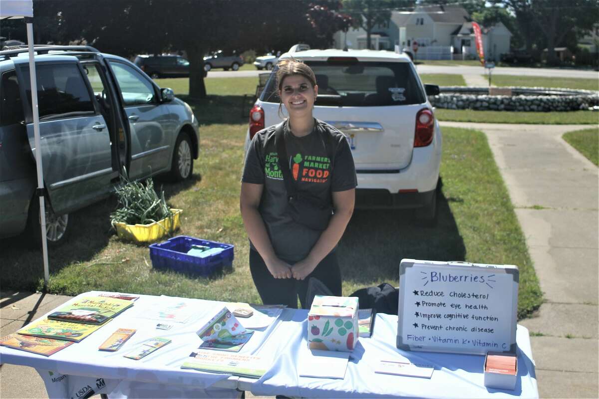 Kylie Davis, a health educator for District Health Department #10, serves as a food navigator at the Manistee Farmers Market.