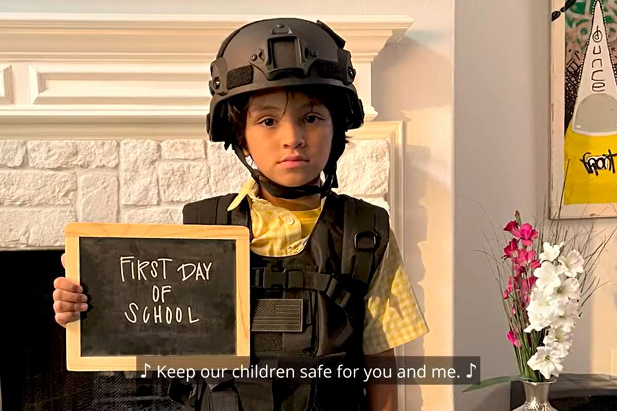A child dresses in body armor and a helmet for the first day of school in a new ad by the Mothers Against Greg Abbott PAC. 