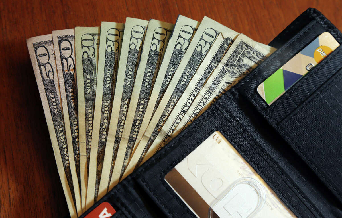 FILE - Cash is fanned out from a wallet in North Andover, Mass., June 15, 2018. The Michigan Department of Treasury's MI Student Aid Team has recommendations for those dealing with student loans.