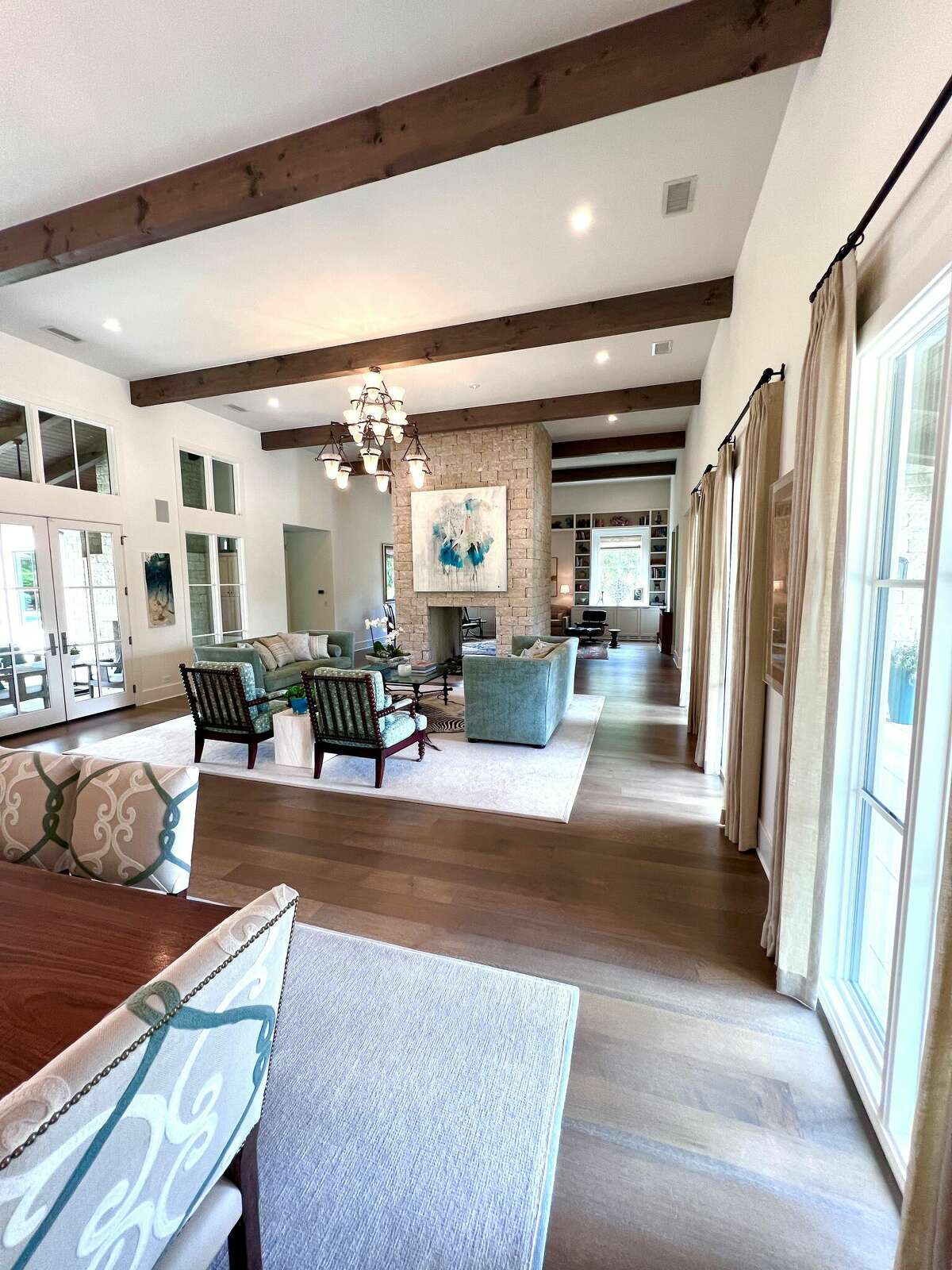 The heart of the house is the great room. Measuring more than 55 feet long and 23 feet wide with 14-foot ceilings, it encompasses the kitchen, dining and living areas, a large see-through fireplace and an informal study/TV space.