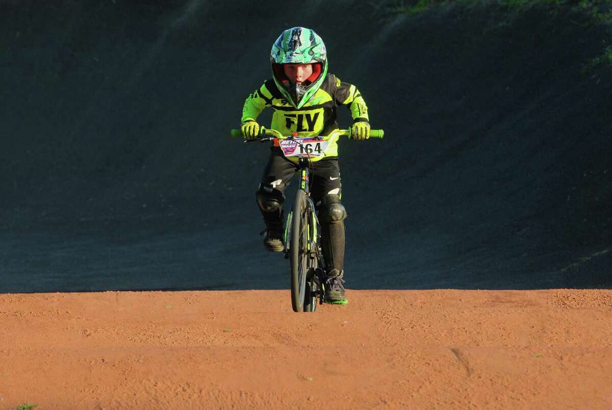 Everett Williams, 8, of Southbury,takes a practice lap before BMX race night at the Trumbull BMX track at Indian Ledge State Park on August 20, 2019.
