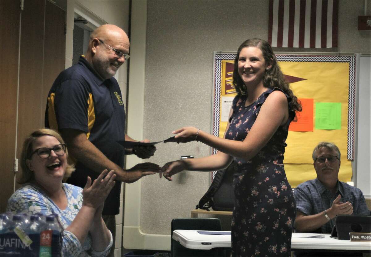 Taylor Mellon (right), fifth grade teacher, accepts her certificate of tenure from Ron Stoneman, Manistee Area Public Schools superintendent, during a school board meeting on Aug. 10.