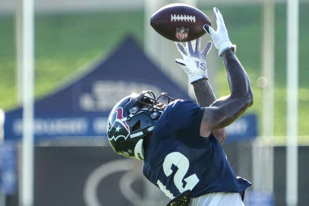 Houston Texans wide receiver Nico Collins (12) reaches over his shoulder to make a catch during an NFL training camp Tuesday, Aug. 16, 2022, in Houston.