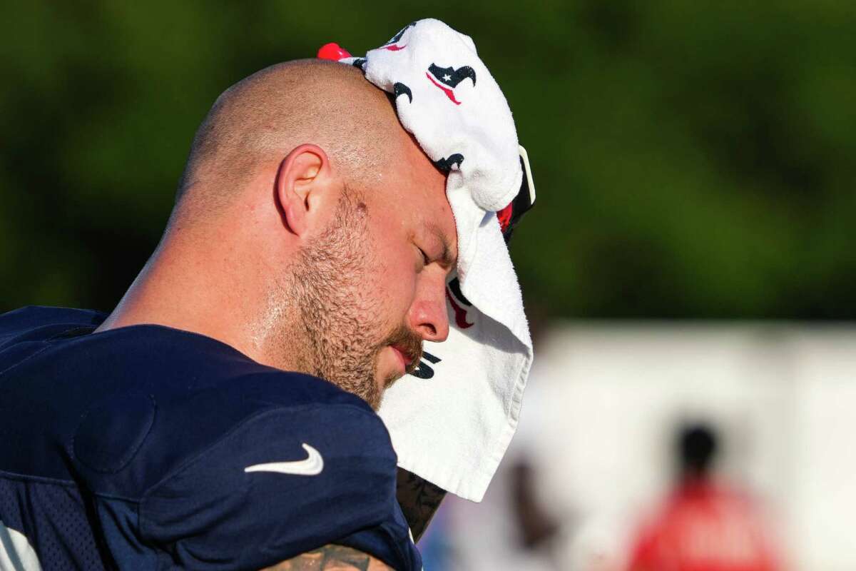 Houston Texans center Justin Britt wipes off his head during an NFL training camp Tuesday, Aug. 16, 2022, in Houston.