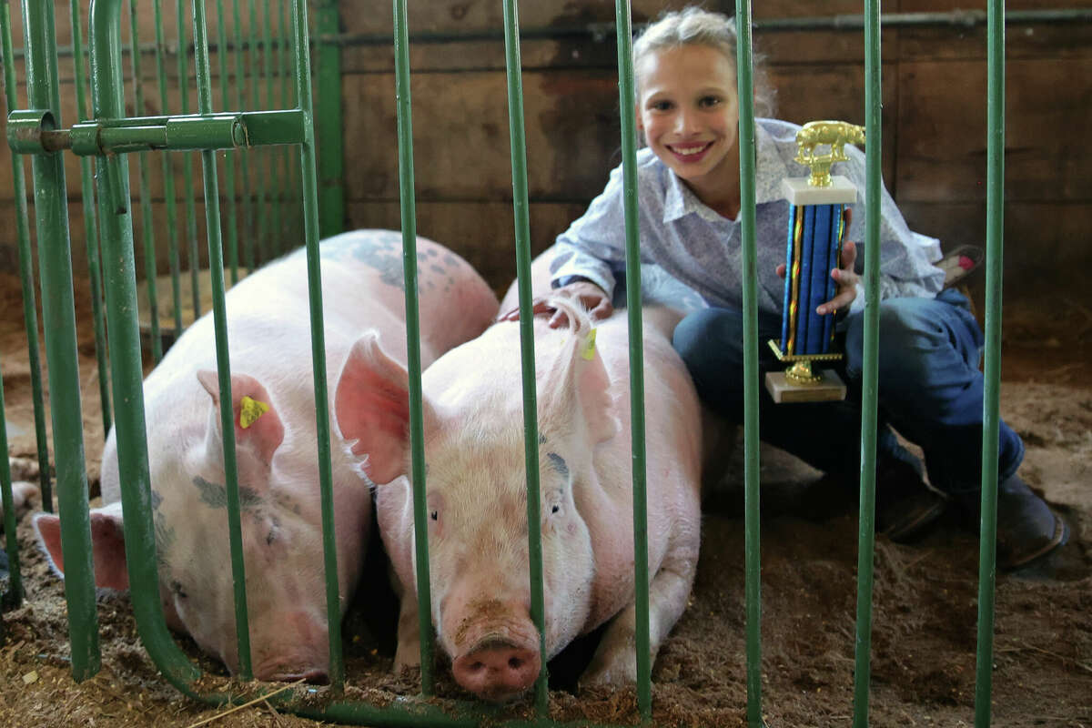Emma Bradford, 12, poses with her pig, Pearl, at the Manistee County Fair in Onekama on Tuesday. Bradford was the grand winner of the 4-H swine show.
