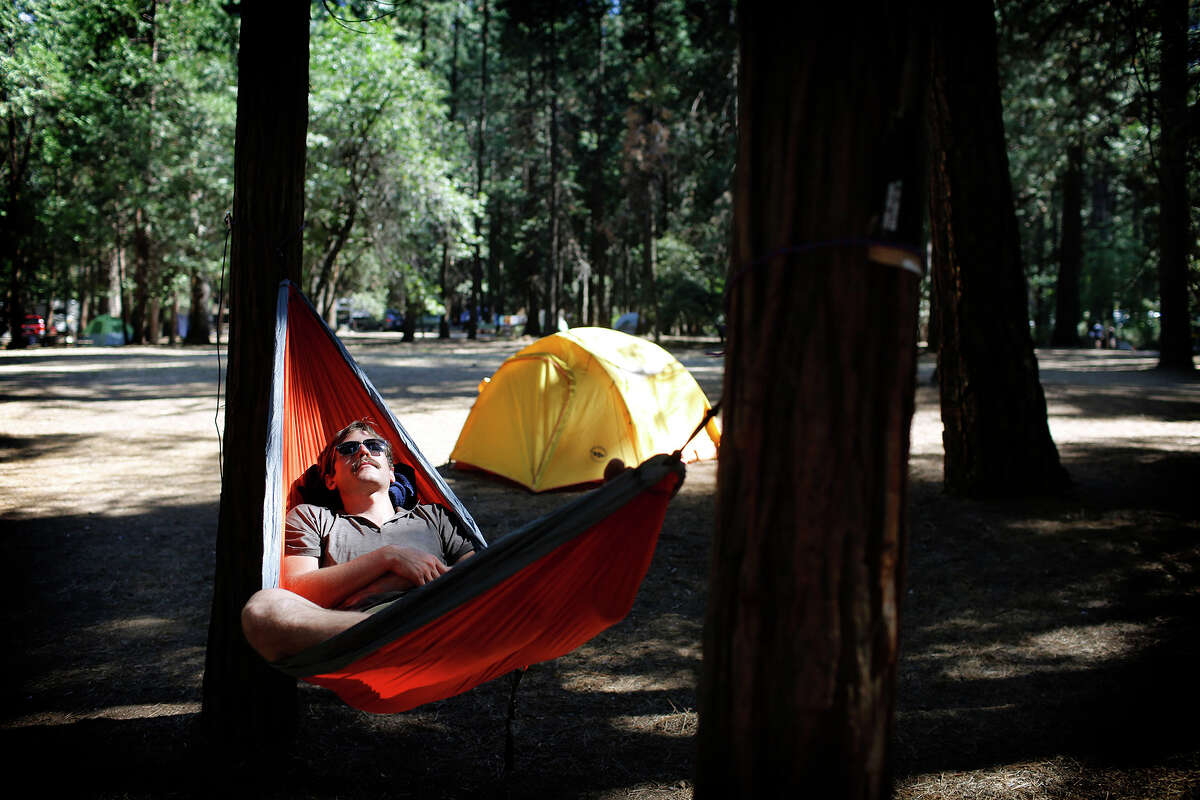 Mason Kropp rests in his hammock Aug. 15, 2015, directly across from where park officials say an oak tree limb fell on a tent in the heart of Yosemite National Park, killing two young campers.