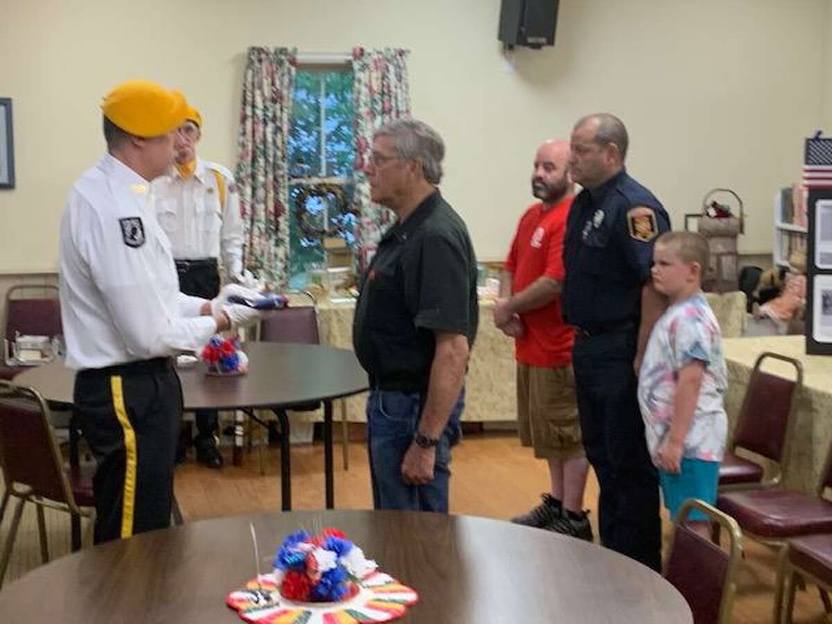 Riverton American Legion Post #159 Color Guard presents retired American flag to July Veteran of the Month, U.S. Marine Corps. Chaplain David McGee, Vietnam War veteran, while his family looks on.