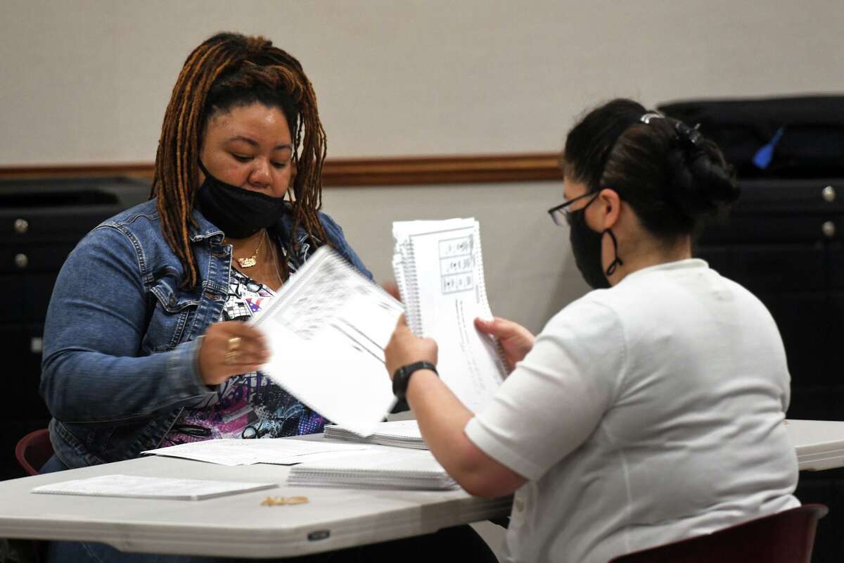 Election moderators recount ballots from last week’s state House 127th District primary, in Bridgeport, Conn. Aug. 16, 2022. Last week’s results showed City Councilman Marcus Brown defeated incumbent state Rep. Jack Hennessy by five votes, but the recount ended with Hennessy leading by a single vote and nine ballots unaccounted for.