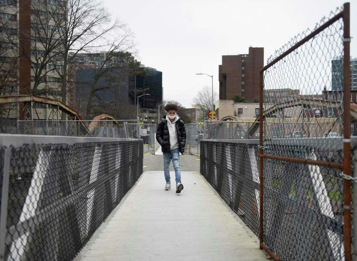A pedestrian walks across the West Main Street Bridge in Stamford, Conn. Monday, Jan. 3, 2022. The Board of Representatives will vote Monday on an ordinance that urges the mayor to restore the West Main Street Bridge with vehicular traffic.