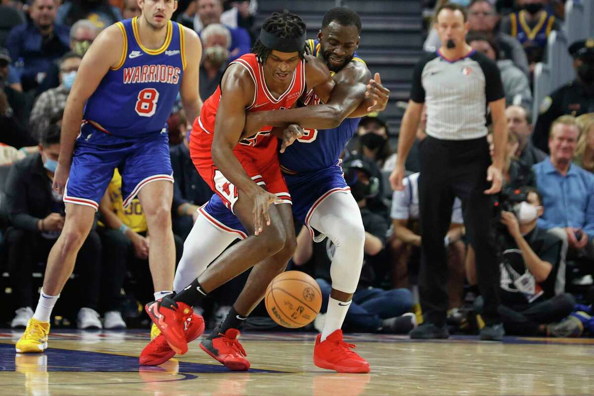 Golden State Warriors forward Draymond Green and Chicago Bulls forward Alize Johnson fights for the ball during the first quarter of their NBA basketball game in San Francisco, Calif. Friday, Nov. 12, 2021.
