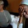 Lateka Thomas, right, on Tuesday, Aug. 16, 2022, at a hotel in Houston, wipes away tears as she talks about her hopelessness after she and her family were locked out from their rental and cut off from their possessions.