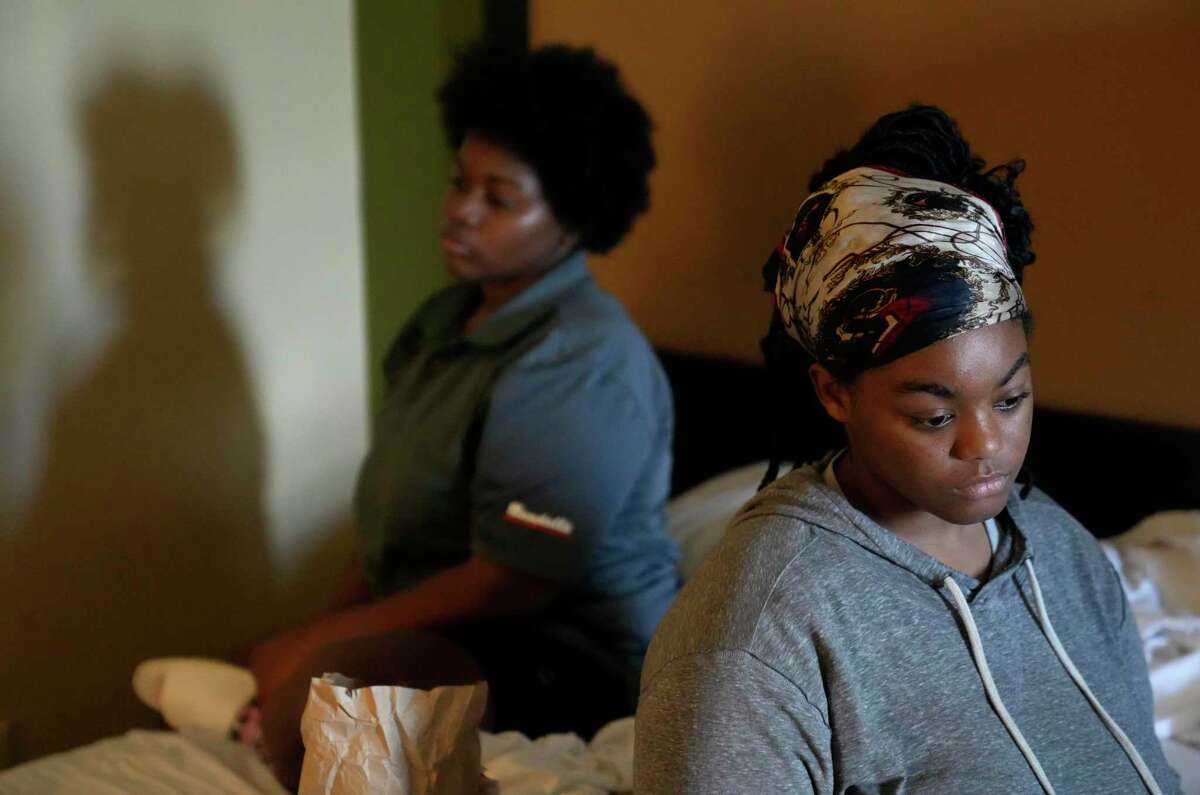 Nautica Thoma, 14, left, and her sister, Aaliyah Anderson, right, listen as their mother, Lateka Thomas, talks about her hopelessness after they were locked out from their rental and cut off from their possessions. Photographed at a hotel Tuesday, Aug. 16, 2022, in Houston.