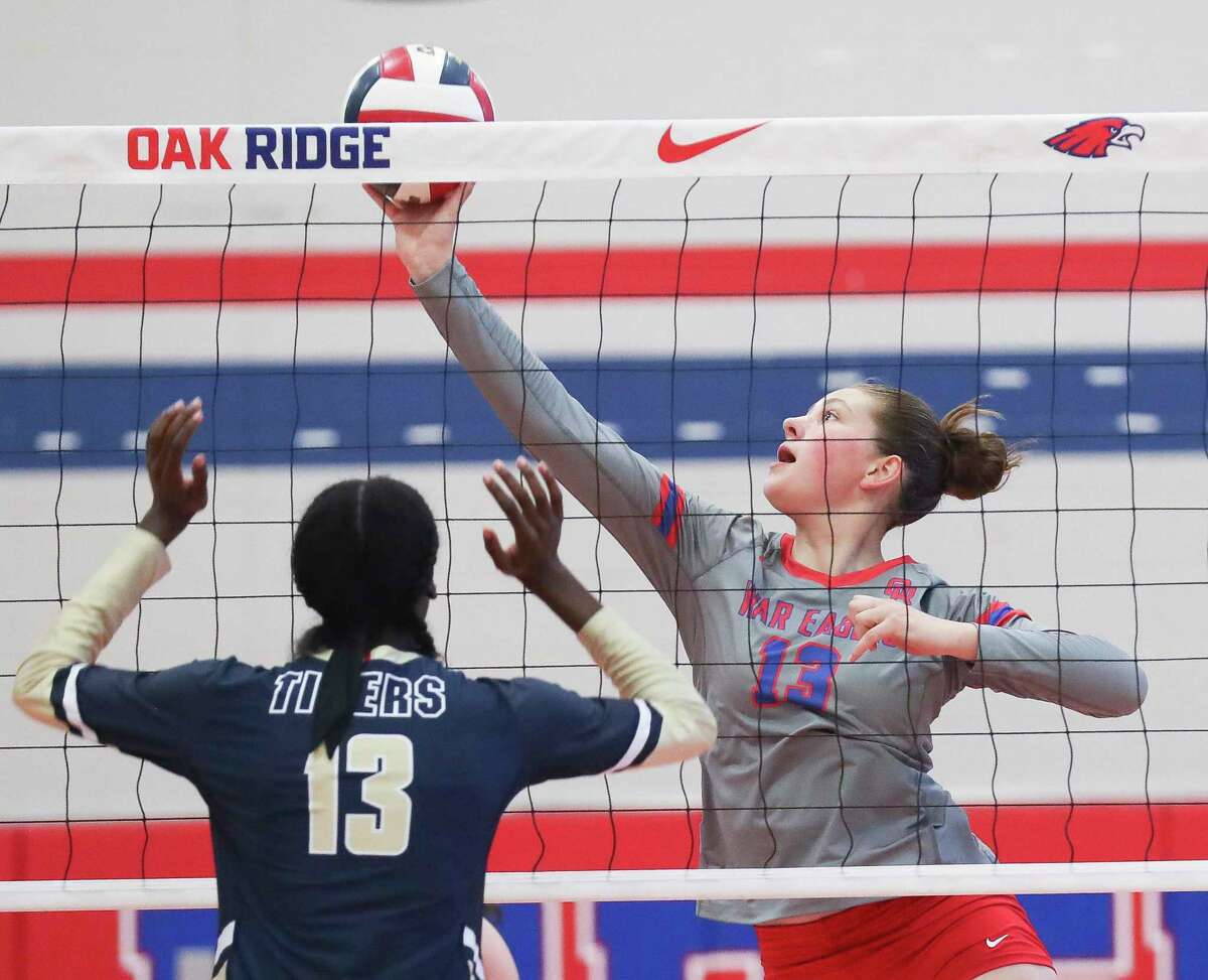 Oak Ridge's Jade Day (13) tips the ball against Klein Collins' Ashlynn Hollis (13) in the first set of a non-district high school volleyball match at Oak Ridge High School, Tuesday, Aug. 16, 2022, in Oak Ridge North.