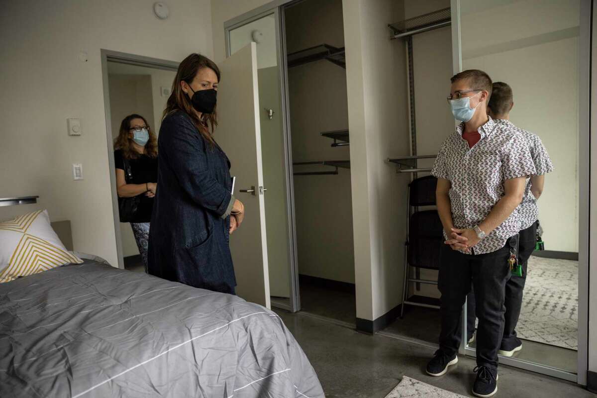 Lauren Hall (center), director and co-founder of Delivering Innovation in Supportive Housing, and Eli White (right), clinical social worker supervisor at UCSF Citywide Roving Team, visit a room at the Panoramic Hotel in San Francisco.