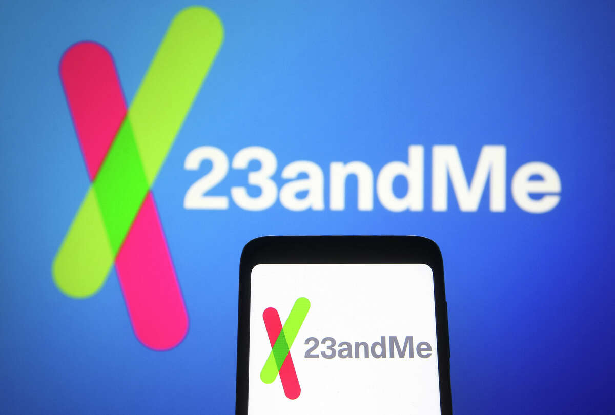 FILE PHOTO In this photo illustration, 23andMe logo of a biotechnology company is seen on a smartphone and a pc screen in the background