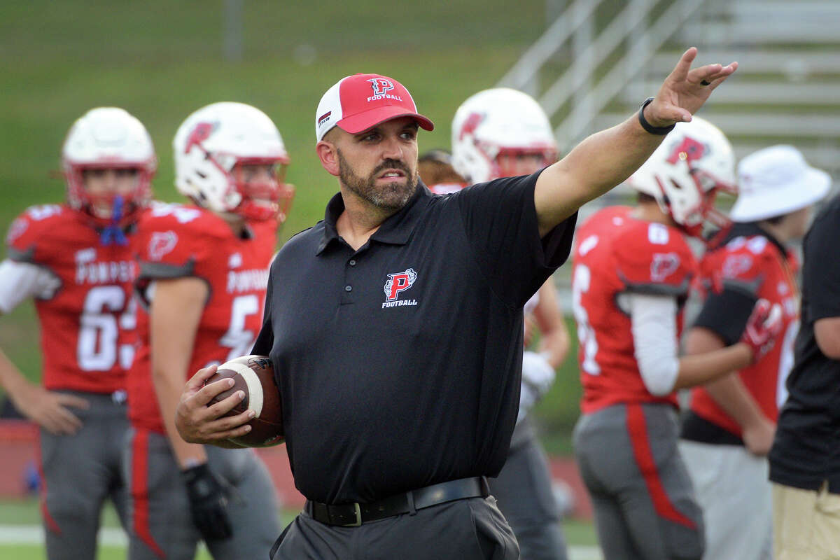 Pomperaug High School head football coach Tony Pereira works with his team prior to a game in Southbury, Conn. Sept. 17, 2021.