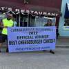 Carrie Sprague (left) holding the winning banner of this year's cheeseburger festival best cheeseburger contest. (courtesy photo)