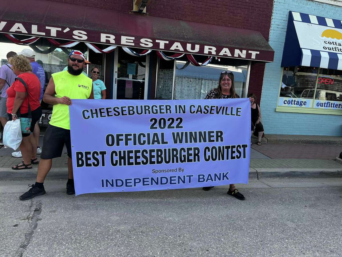 Carrie Sprague (left) holds the winning banner of this year's cheeseburger festival best cheeseburger contest. 