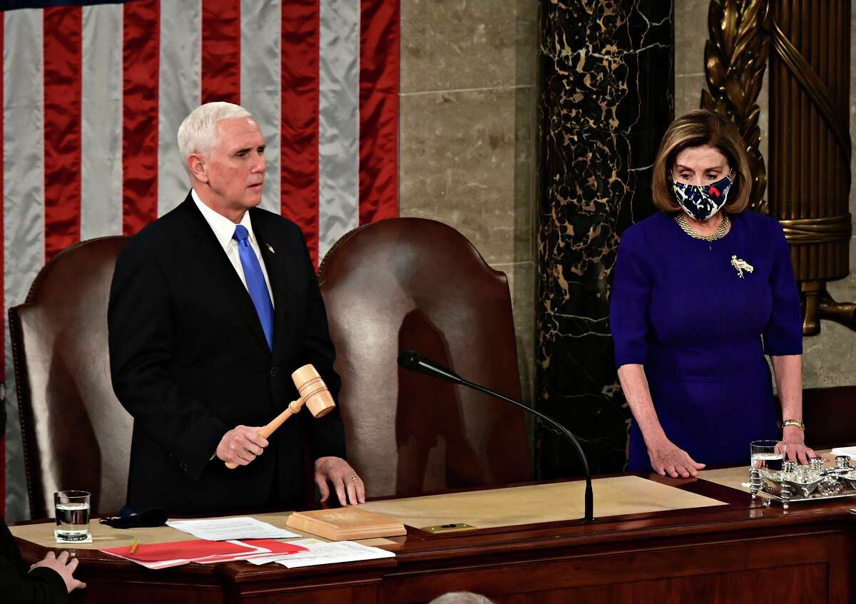 Speaker of the House Nancy Pelosi, right, listens as Vice President Mike Pence speaks during a joint session of Congress to count the Electoral College votes of the 2020 presidential election in the House Chamber on Jan. 6, 2021, in Washington, D.C.
