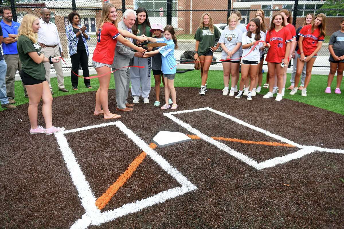 Mayor Harry Rilling is joined by softball players as he cuts a ribbon for the new softball field at Brien McMahon High School, in Norwalk, Conn. Aug 17, 2022.