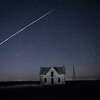 File-In this photo taken May 6, 2021, with a long exposure, a string of SpaceX StarLink satellites passes over an old stone house near Florence, Kan. The train of lights was actually a series of relatively low-flying satellites launched by Elon Musk's SpaceX as part of its Starlink internet service earlier this week. (AP Photo/Reed Hoffmann, File)