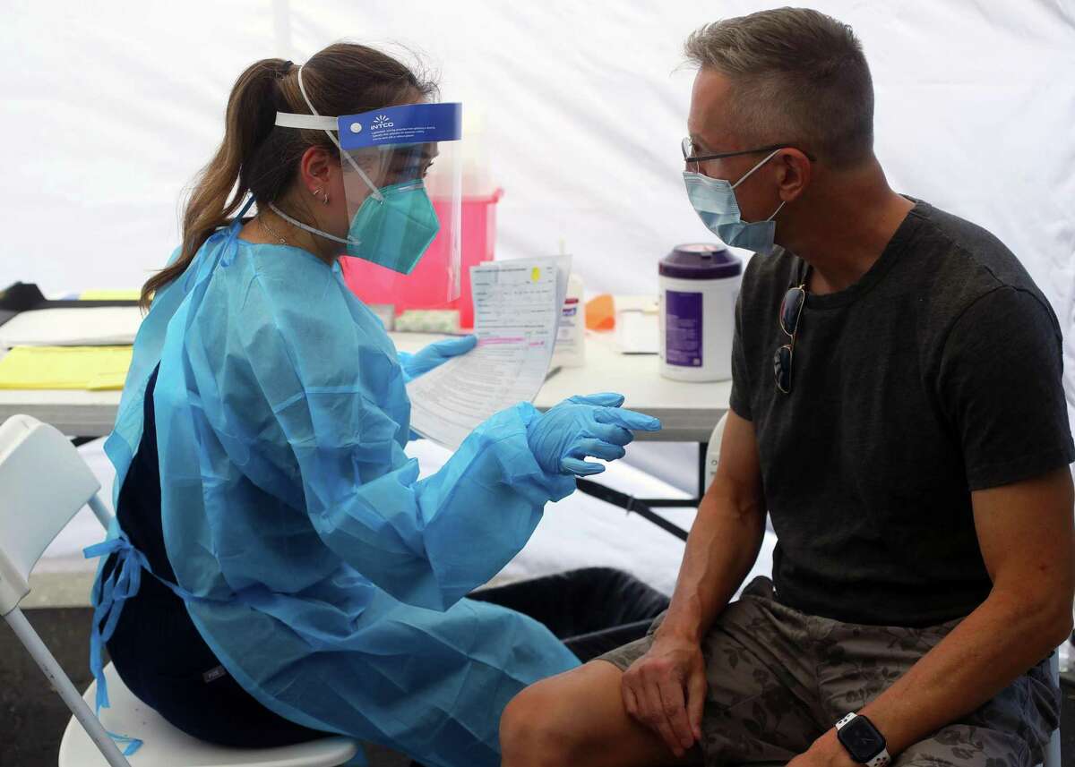 Pharmacist Michelle Huynh (left) prepares a monkeypox vaccine shot for Eric Tooley in San Jose. Bay Area providers have started using a new method that stretches the vaccine to allow more doses.