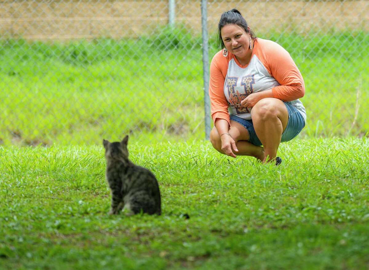 Danielle Poole watches a family of stray cats near her home on Saturday, July 30, 2022 in Pearland.