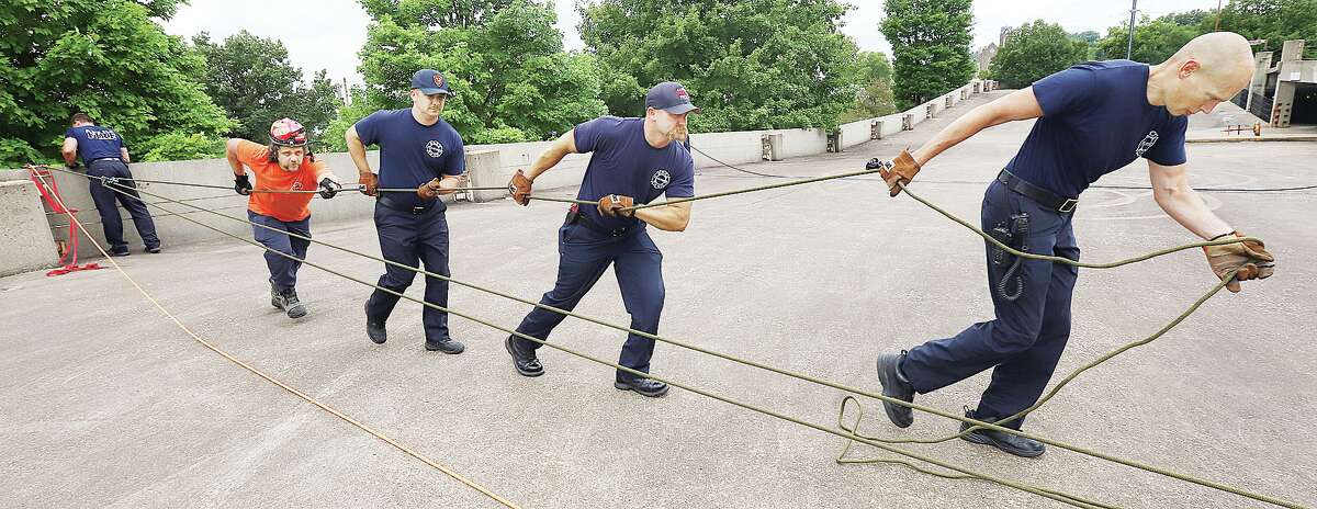 Firefighters perform a "haul" to raise a firefighter back up from the ground. The same technique is used to raise both firefighters and victims during a rescue effort.