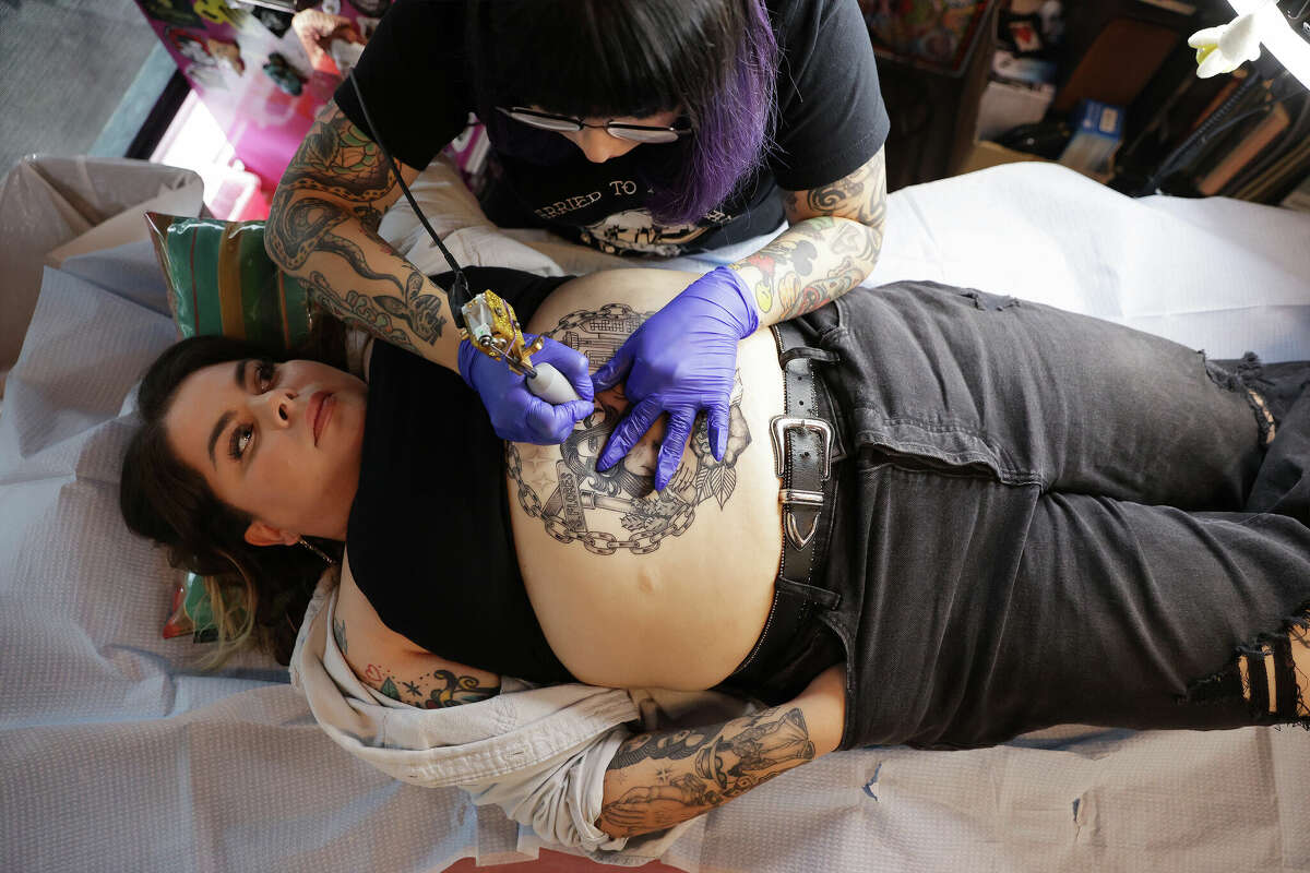 Tattoo artist Esther Quiara works on her friend, Amanda Galindo at Into the Void, the 1-year-old business Quiara owns and operates.  