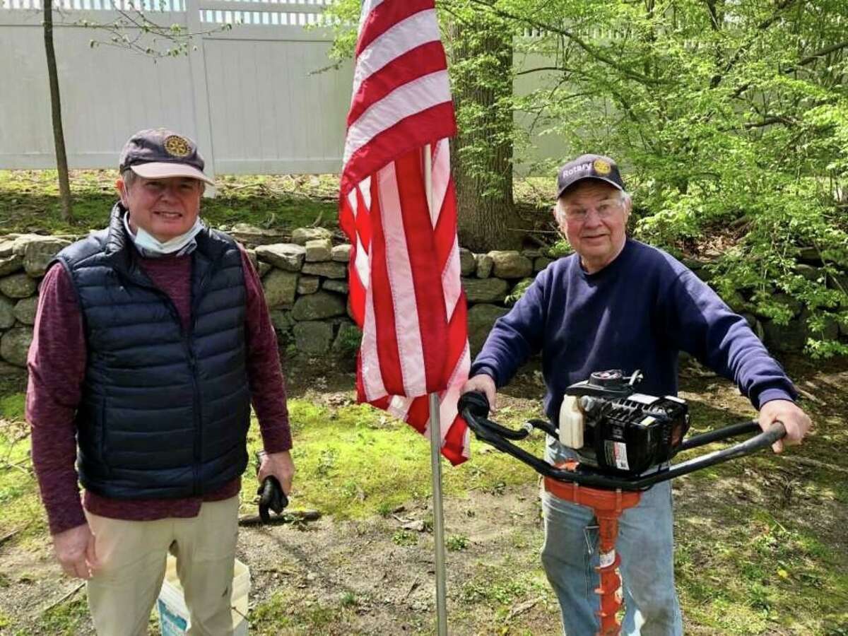 From left, Ridgefield Rotary Club members Jim Finklea and Mike Anderson worked together to install American flags in front of Ridgefield homes and businesses this spring as part of the club's annual Fly the Colors program.