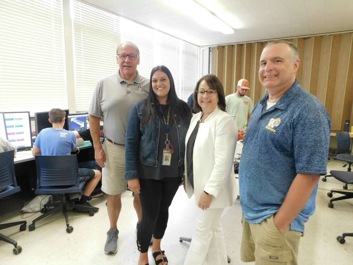 From left, Chris Smedick, executive director of Torrington PAL; Stephanie Seitlinger, Oliver Wolcott Technical School dean of students; Gail Duffy, OWTS assistant principal; and Ray Tanguay, OWTS mechanical design and engineering department head, pose while middle school students work on projects during a labor trade camp at OWTS.