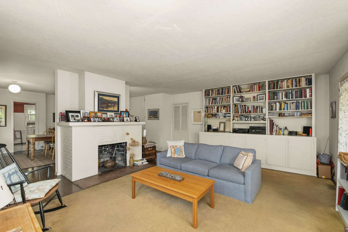 The living room has plenty of bookshelves and a fireplace.