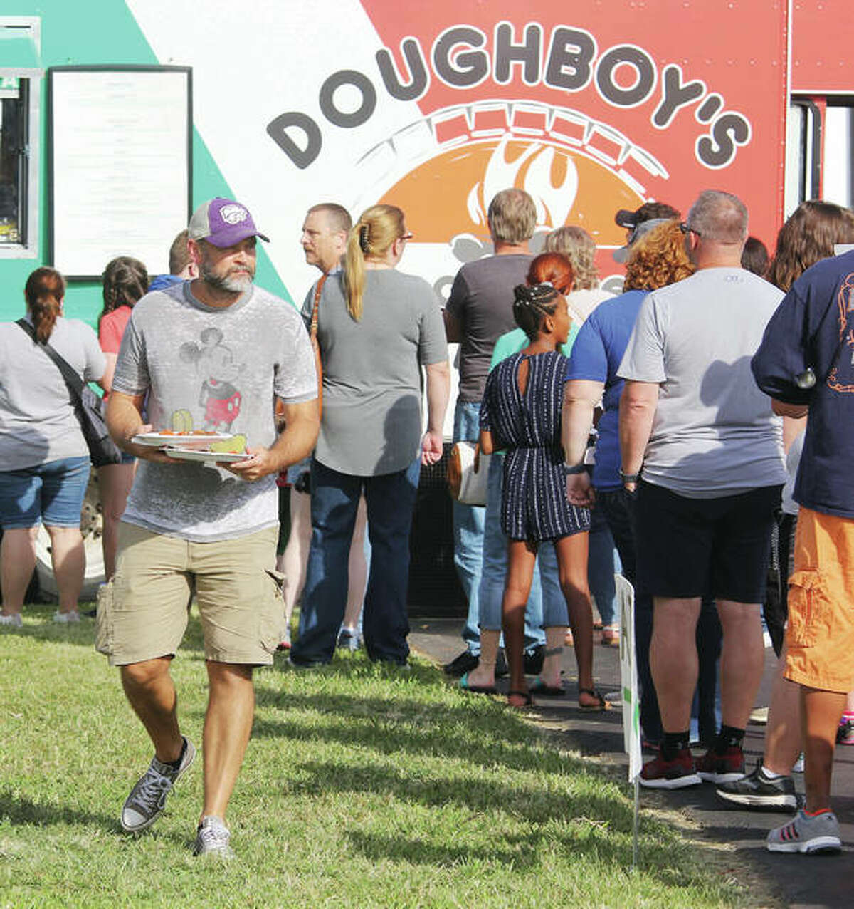 Tim Black, of Holiday Shores, in 2019 carries two pepperoni pizzas from Doughboy’s which is returning this year for the Alton Food Truck Festival 4-8 p.m. Saturday, Aug. 27 at the Liberty Bank Amphitheater in Alton.
