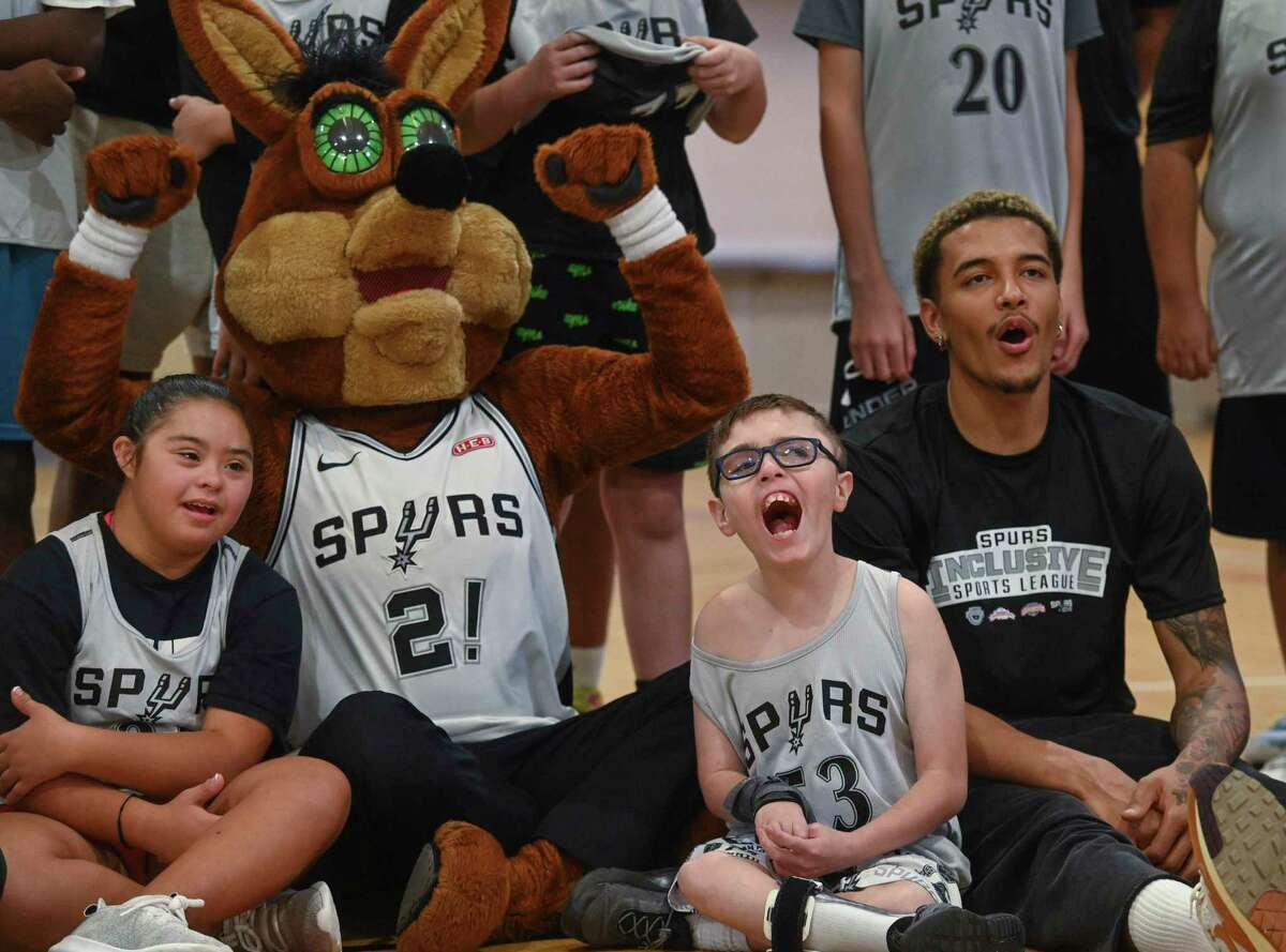 Olivia Garza, from left, sits with the Spurs’ Coyote, Benjamin Kelley and Spurs rookie Jeremy Sochan during a night of basketball for children in the Spurs Inclusive Sports League at Morgan’s Wonderland on Wednesday.